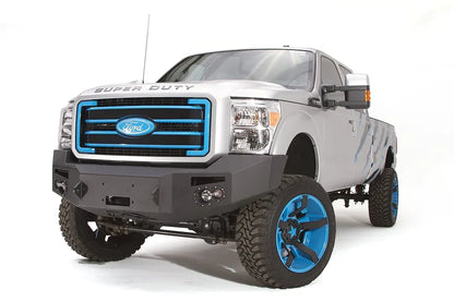 Fab Fours Premium Heavy Duty winch front bumper on a silver Ford Super Duty, front driver-side three-quarter view, showing the winch opening, integrated lights and bumper end cap
