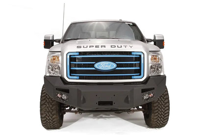 Fab Fours Premium Heavy Duty winch front bumper on a silver Ford Super Duty, straight-on front view, showing the winch opening, integrated lights and wraparound wings