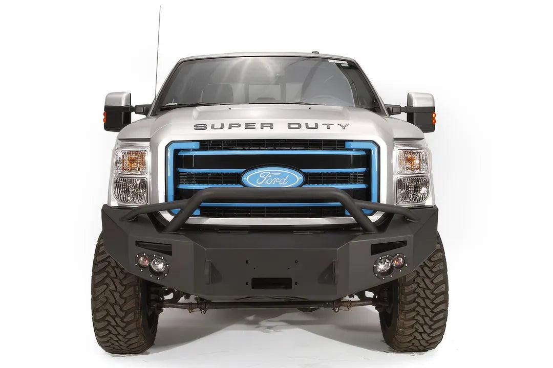 Fab Fours Premium Heavy Duty winch front bumper with pre-runner guard on a silver Ford Super Duty, straight-on front view, showing the tubular pre-runner hoop, winch opening and integrated lights
