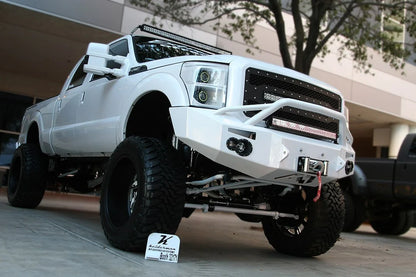 Fab Fours Premium Heavy Duty winch front bumper with pre-runner guard in white on a white Ford Super Duty outdoors, front passenger-side three-quarter view, showing the pre-runner hoop, winch and integrated lights