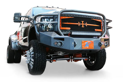 Fab Fours Premium Heavy Duty winch front bumper with full guard on a wrapped white Ford Super Duty dually outdoors, front passenger-side three-quarter view, showing the full grille guard, integrated lights and bumper wing