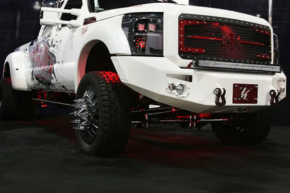Fab Fours Premium Heavy Duty winch front bumper in white on a white Ford Super Duty dually, front passenger-side three-quarter view, showing the bumper face, D-ring shackles and integrated lights