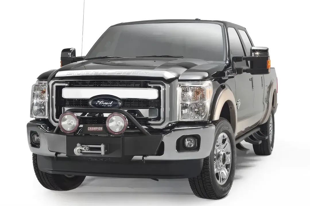 Fab Fours winch mount on a black and tan Ford Super Duty, front three-quarter view, showing the winch, light hoop and round off-road lights