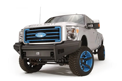 Fab Fours Black Steel Elite front bumper on a silver Ford Super Duty, front driver-side three-quarter view, showing the smooth plate face, mesh wing inserts and bumper end cap