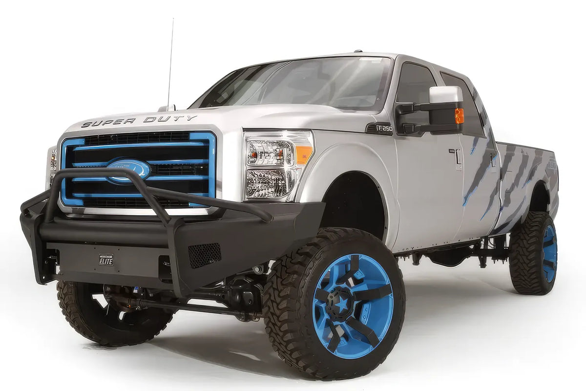 Fab Fours Black Steel Elite front bumper with pre-runner guard on a silver Ford Super Duty, front driver-side three-quarter view, showing the tubular pre-runner hoop, smooth plate face and Elite badge