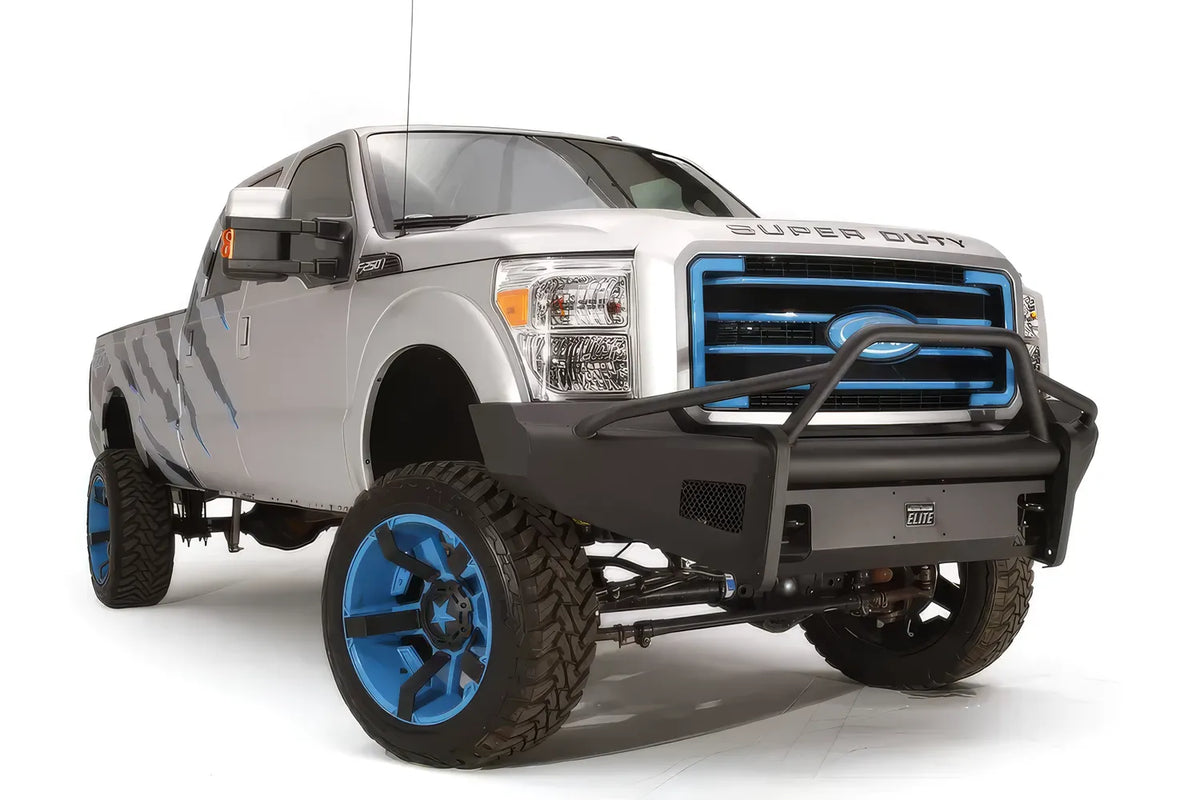 Fab Fours Black Steel Elite front bumper with pre-runner guard on a silver Ford Super Duty, front passenger-side three-quarter view, showing the pre-runner hoop, mesh wing inserts and Elite badge