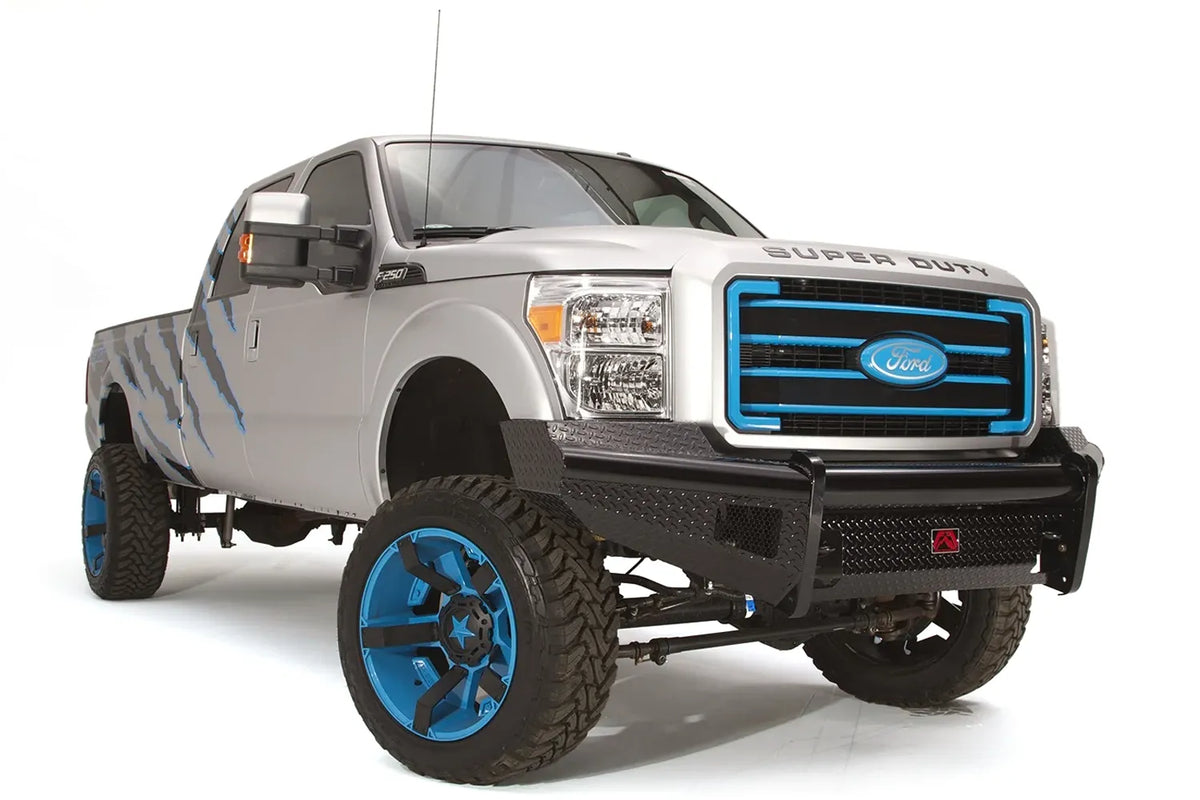 Fab Fours Black Steel front ranch bumper on a silver Ford Super Duty, front passenger-side three-quarter view, showing the diamond-plate face, bumper wing and center logo plate