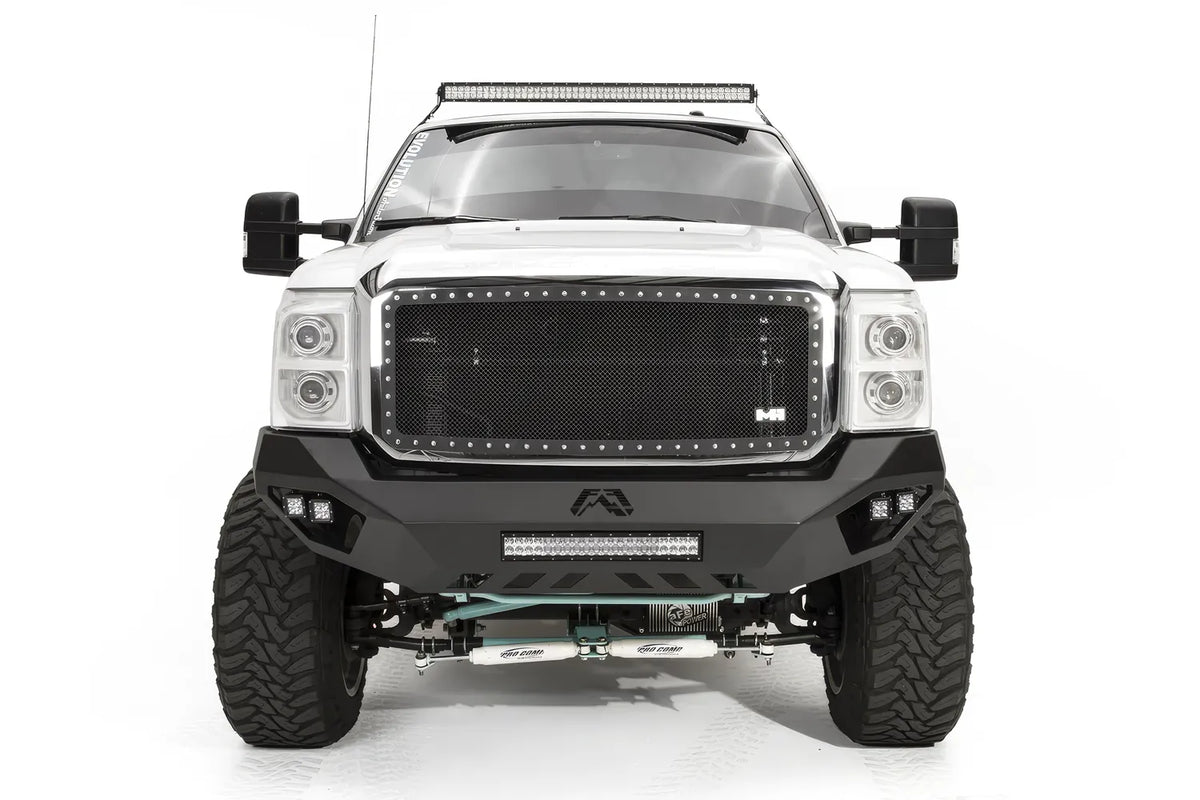 Fab Fours Vengeance front bumper on a white Ford Super Duty, straight-on front view, showing the center light bar, Fab Fours logo cutout and corner pod lights