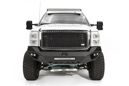 Fab Fours Vengeance front bumper on a white Ford Super Duty, straight-on front view, showing the center light bar, Fab Fours logo cutout and corner pod lights