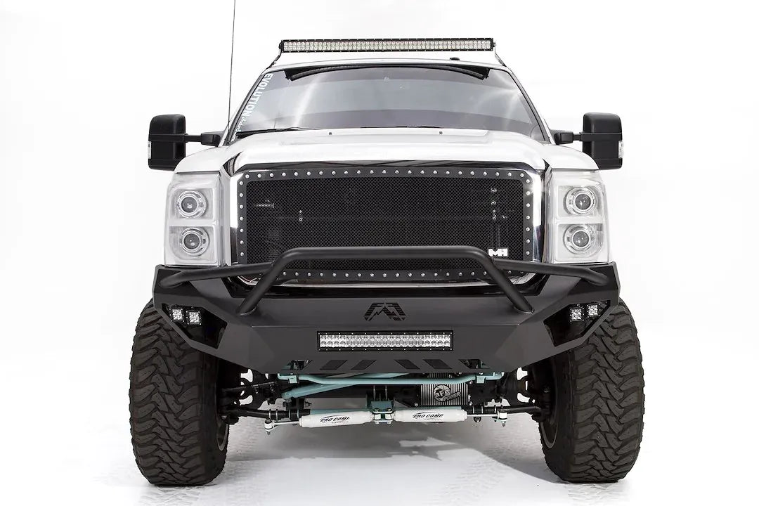 Fab Fours Vengeance front bumper with pre-runner guard on a white Ford Super Duty, straight-on front view, showing the pre-runner hoop, center light bar and Fab Fours logo cutout