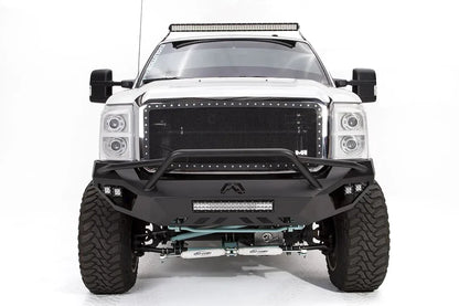 Fab Fours Vengeance front bumper with pre-runner guard on a white Ford Super Duty, straight-on front view, showing the pre-runner hoop, center light bar and Fab Fours logo cutout