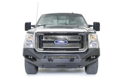 Fab Fours Matrix front winch bumper on a black and tan Ford Super Duty, straight-on front view, showing the center light bar, winch opening and corner pod lights