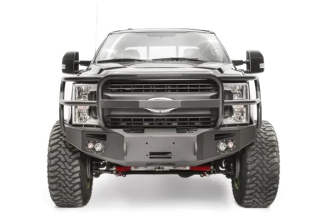 Fab Fours Premium winch front bumper with full guard on a black Ford Super Duty, straight-on front view, showing the full grille guard, winch opening and pair of integrated lights