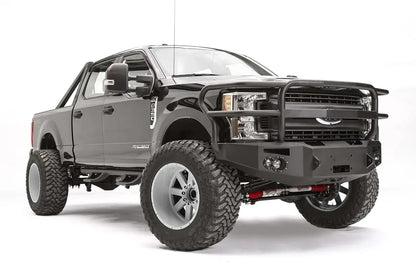 Fab Fours Premium winch front bumper with full guard on a black Ford Super Duty, front passenger-side three-quarter view, showing the full grille guard, headlight hoops and integrated lights