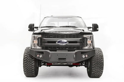 Fab Fours Premium winch front bumper on a black Ford Super Duty, straight-on front view, showing the winch opening, pair of integrated lights and wraparound wings