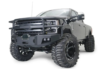Fab Fours Premium winch front bumper with full guard on a gray Ford Super Duty, front driver-side three-quarter view, showing the full tubular grille guard, winch cover and integrated lights