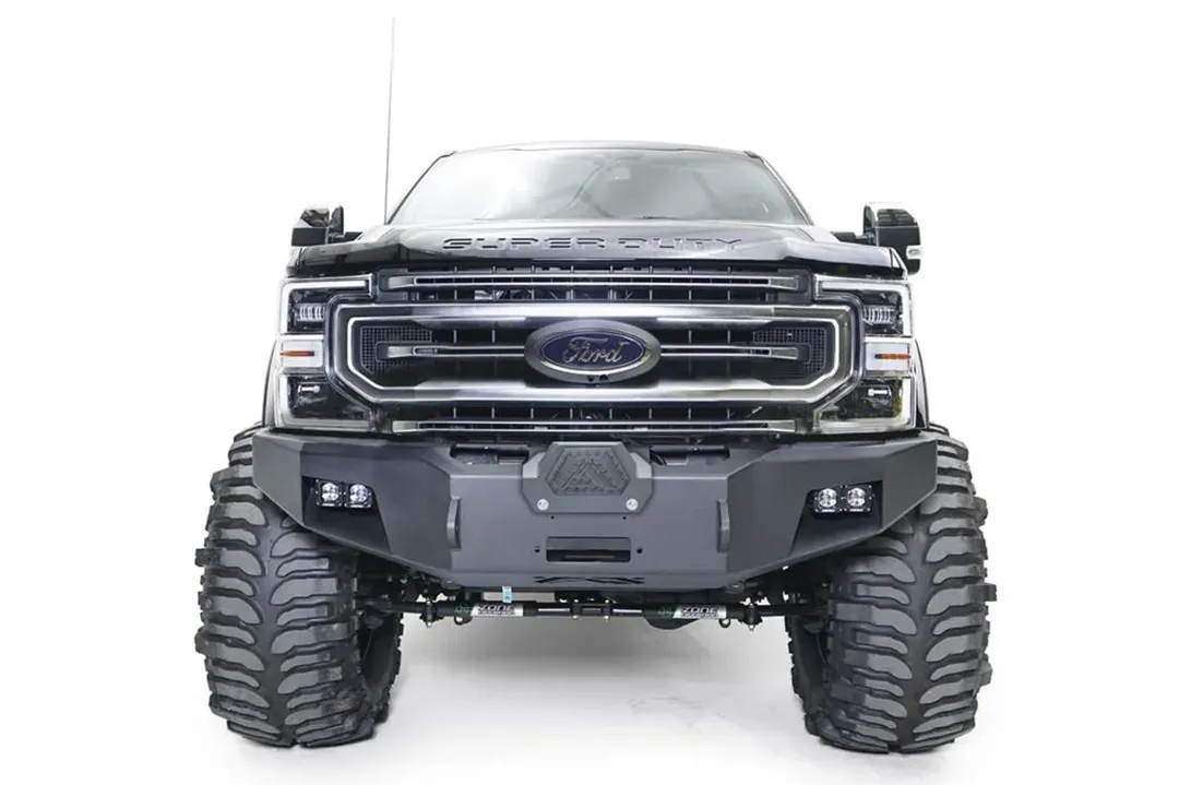 Fab Fours Premium Winch front bumper on a black Ford Super Duty, straight-on front view, showing the center winch opening, flush-mounted LED light pods, and angular steel end caps