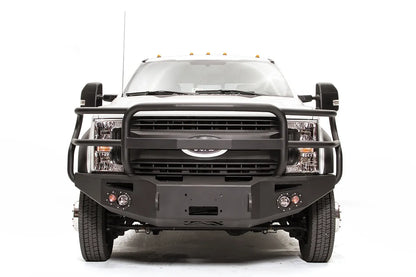 Fab Fours Premium Winch front bumper with full guard on a white Ford Super Duty F-450/F-550, straight-on front view, showing full grille guard hoops, the center winch opening, round light cutouts, and angular steel end caps