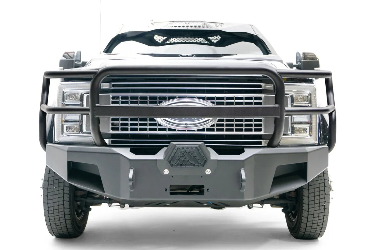 Fab Fours Premium Winch front bumper with full guard on a black Ford Super Duty XL F-450/F-550, straight-on front view, showing full grille guard hoops, the center winch opening, and angular steel end caps