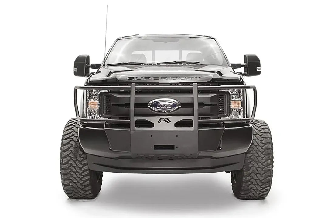 Fab Fours winch mount with full guard on a black Ford Super Duty, straight-on front view, showing full grille guard uprights, the winch mount plate, and the factory bumper integration