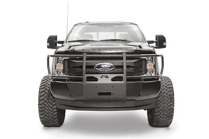 Fab Fours winch mount with full guard on a black Ford Super Duty, straight-on front view, showing full grille guard uprights, the winch mount plate, and the factory bumper integration