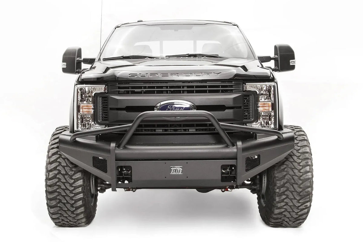 Fab Fours Black Steel Elite front bumper with pre-runner guard on a black Ford Super Duty, straight-on front view, showing the tubular pre-runner hoop, the smooth steel face, mesh-backed side openings, and the center license plate mount