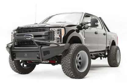 Fab Fours Black Steel Elite front bumper with pre-runner guard on a black Ford Super Duty, front driver-side three-quarter view, showing the tubular pre-runner hoop, the smooth steel face, mesh-backed side openings, and the center license plate mount