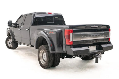 Fab Fours Red Steel rear bumper on a black Ford Super Duty Platinum dually, rear driver-side view with the flat black bumper, plate mount and adjustable ball hitch