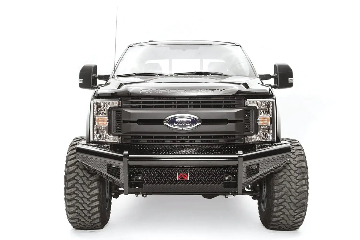 Fab Fours Black Steel front bumper on a black Ford Super Duty, straight-on front view, showing diamond-plate face panels, the center license plate mount, and angled side wings