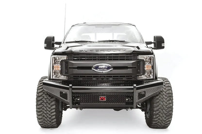 Fab Fours Black Steel front bumper on a black Ford Super Duty, straight-on front view, showing diamond-plate face panels, the center license plate mount, and angled side wings