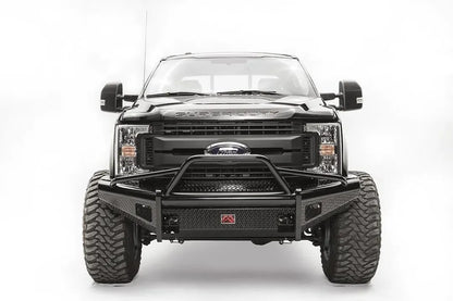 Fab Fours Black Steel front bumper with pre-runner guard on a black Ford Super Duty, straight-on front view, showing the tubular pre-runner hoop, diamond-plate face panels, the center license plate mount, and angled side wings