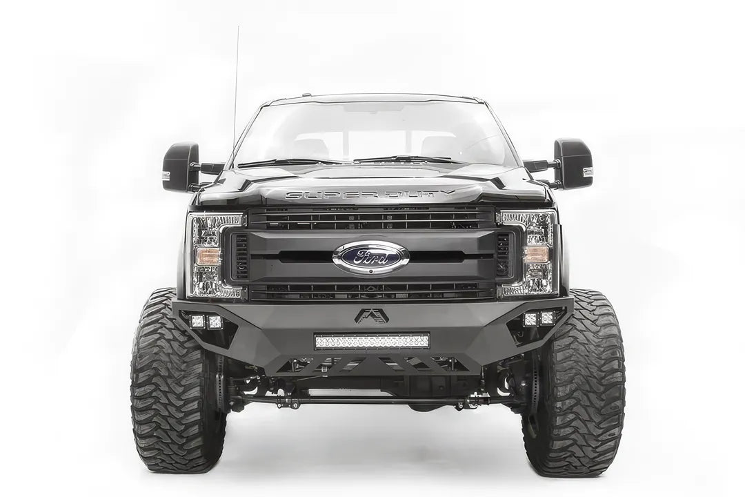 Fab Fours Vengeance front bumper on a black and gray Ford Super Duty F-250/F-350, straight-on front view, showing the center LED light bar, cube light pods, and the open skid plate design