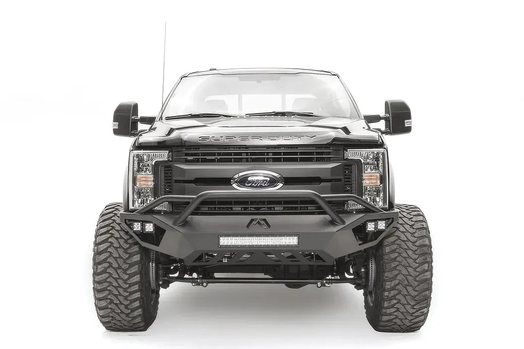 Fab Fours Vengeance front bumper with pre-runner guard on a black and gray Ford Super Duty F-250/F-350, straight-on front view, showing the tubular pre-runner hoop, the center LED light bar, cube light pods, and the open skid plate design
