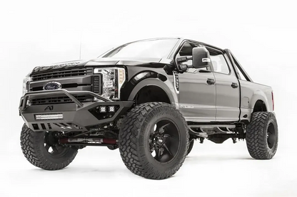 Fab Fours Vengeance front bumper with pre-runner guard on a black and gray Ford Super Duty F-250/F-350, front driver-side three-quarter view, showing the tubular pre-runner hoop, the center LED light bar, cube light pods, and the open skid plate design