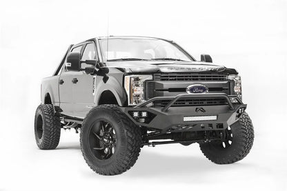 Fab Fours Vengeance front bumper with pre-runner guard on a black and gray Ford Super Duty F-250/F-350, front passenger-side three-quarter view, showing the tubular pre-runner hoop, the center LED light bar, cube light pods, and the open skid plate design