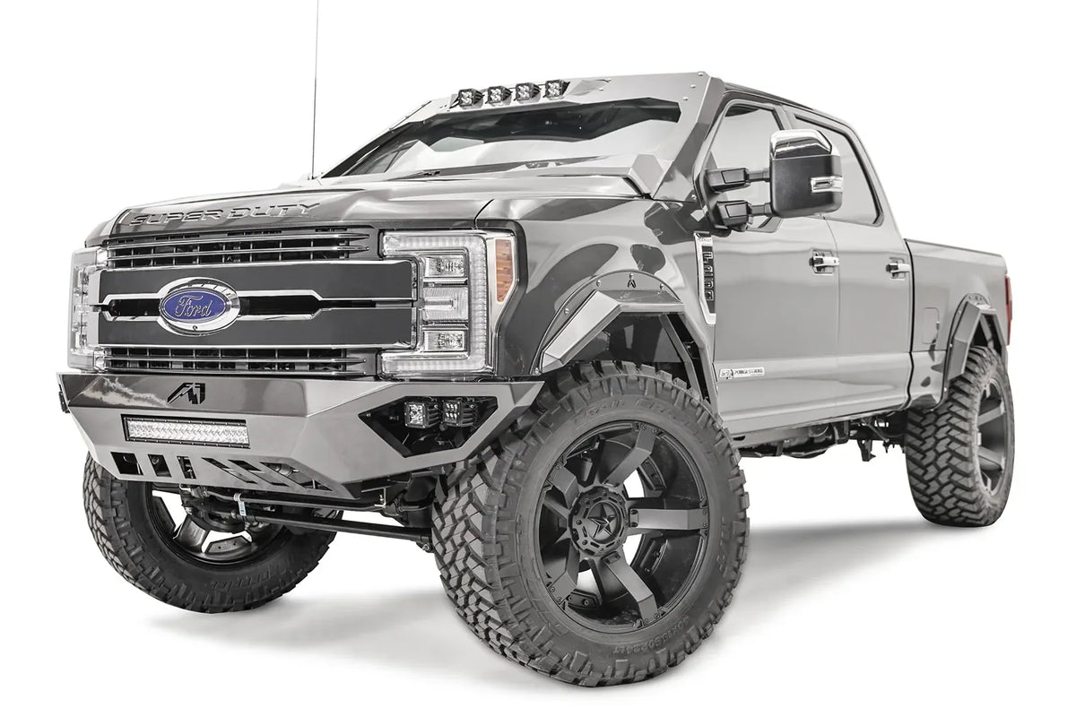 Fab Fours Open Fender front bumper on a gray Ford Super Duty, front driver-side three-quarter view, showing the center LED light bar, cube light pods, and the open-fender wing design