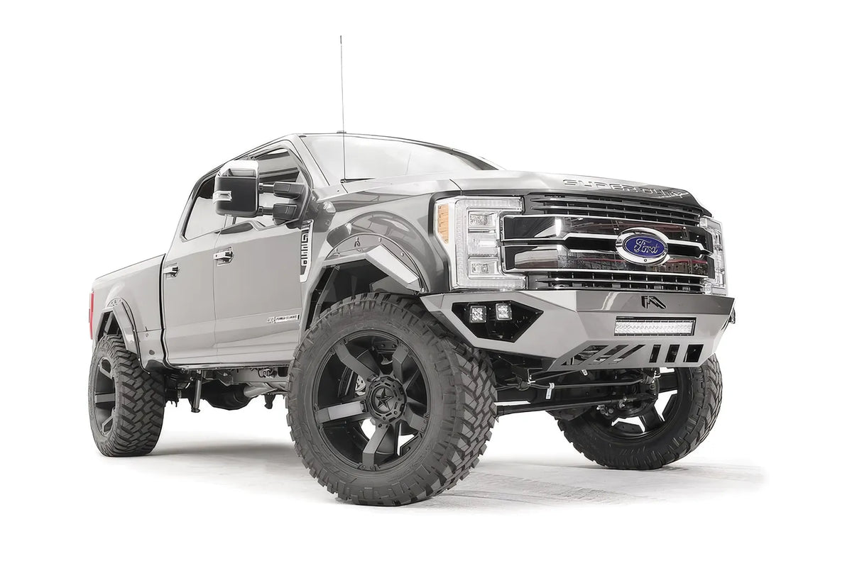 Fab Fours Open Fender front bumper on a gray Ford Super Duty, front passenger-side three-quarter view, showing the center LED light bar, cube light pods, and the open-fender wing design