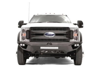 Fab Fours Vengeance front bumper on a white Ford Super Duty F-450/F-550, straight-on front view, showing the center LED light bar, cube light pods, and the open skid plate design