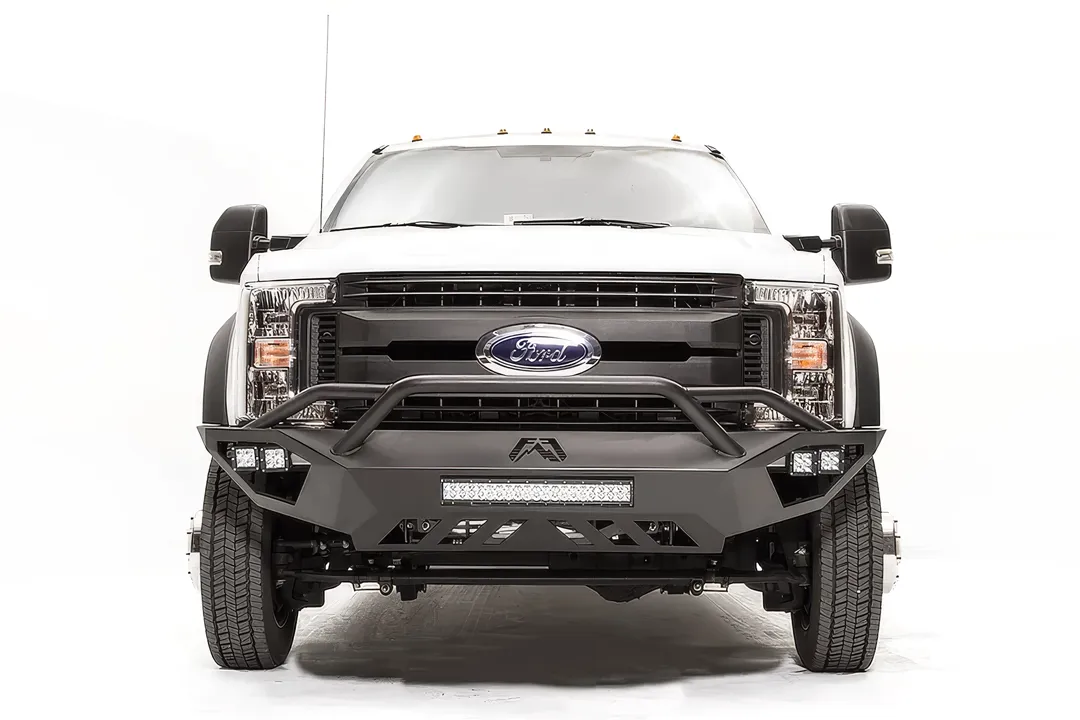 Fab Fours Vengeance front bumper with pre-runner guard on a white Ford Super Duty F-450/F-550, straight-on front view, showing the tubular pre-runner hoop, the center LED light bar, cube light pods, and the open skid plate design