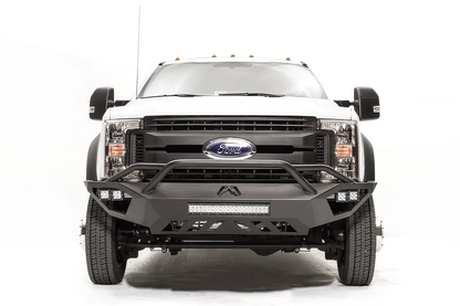 Fab Fours Vengeance front bumper with pre-runner guard on a white Ford Super Duty F-450/F-550, straight-on front view, showing the tubular pre-runner hoop, the center LED light bar, cube light pods, and the open skid plate design