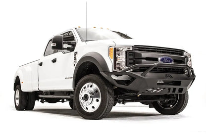 Fab Fours Vengeance front bumper with pre-runner guard on a white Ford Super Duty F-450/F-550, front passenger-side three-quarter view, showing the tubular pre-runner hoop, the center LED light bar, cube light pods, and the open skid plate design