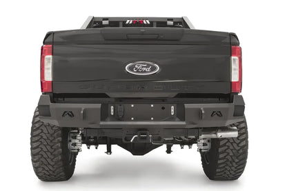 Fab Fours Premium rear bumper on a black Ford Super Duty, straight-on rear view, showing the center license plate recess, integrated light openings, and angular steel end caps