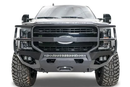 Fab Fours Matrix front bumper with full guard on a black Ford Super Duty F-250/F-350, straight-on front view, showing full grille guard hoops, the center LED light bar, cube light pods, and the integrated winch with shackle mounts