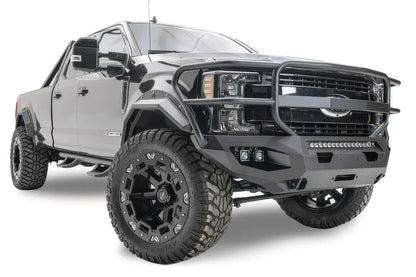 Fab Fours Matrix front bumper with full guard on a black Ford Super Duty F-250/F-350, front passenger-side three-quarter view, showing full grille guard hoops, the center LED light bar, cube light pods, and the integrated winch with shackle mounts