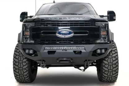 Fab Fours Matrix front bumper on a black Ford Super Duty F-250/F-350, straight-on front view, showing the center LED light bar, cube light pods, and the integrated winch with shackle mounts