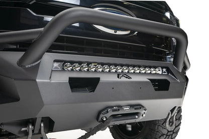 Fab Fours Matrix front bumper with pre-runner guard on a black Ford Super Duty F-250/F-350, close-up of the center section, showing the tubular pre-runner hoop, the center LED light bar, cube light pods, and the integrated winch with shackle mounts