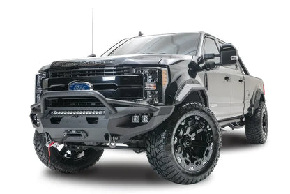 Fab Fours Matrix front bumper with pre-runner guard on a black Ford Super Duty F-250/F-350, front driver-side three-quarter view, showing the tubular pre-runner hoop, the center LED light bar, cube light pods, and the integrated winch with shackle mounts