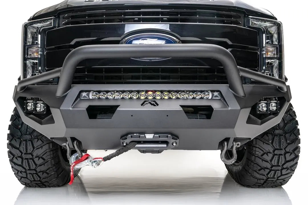 Fab Fours Matrix front bumper with pre-runner guard on a black Ford Super Duty F-250/F-350, straight-on front view, showing the tubular pre-runner hoop, the center LED light bar, cube light pods, and the integrated winch with shackle mounts