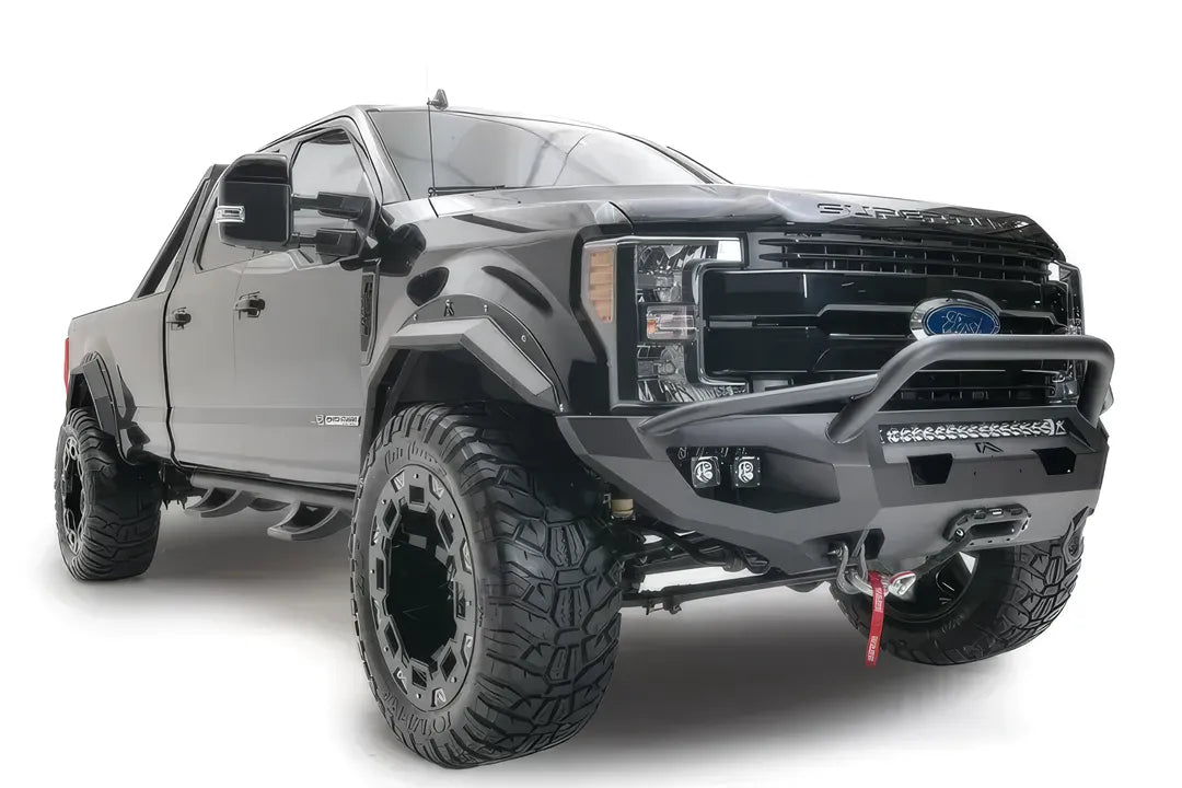 Fab Fours Matrix front bumper with pre-runner guard on a black Ford Super Duty F-250/F-350, front passenger-side three-quarter view, showing the tubular pre-runner hoop, the center LED light bar, cube light pods, and the integrated winch with shackle mounts