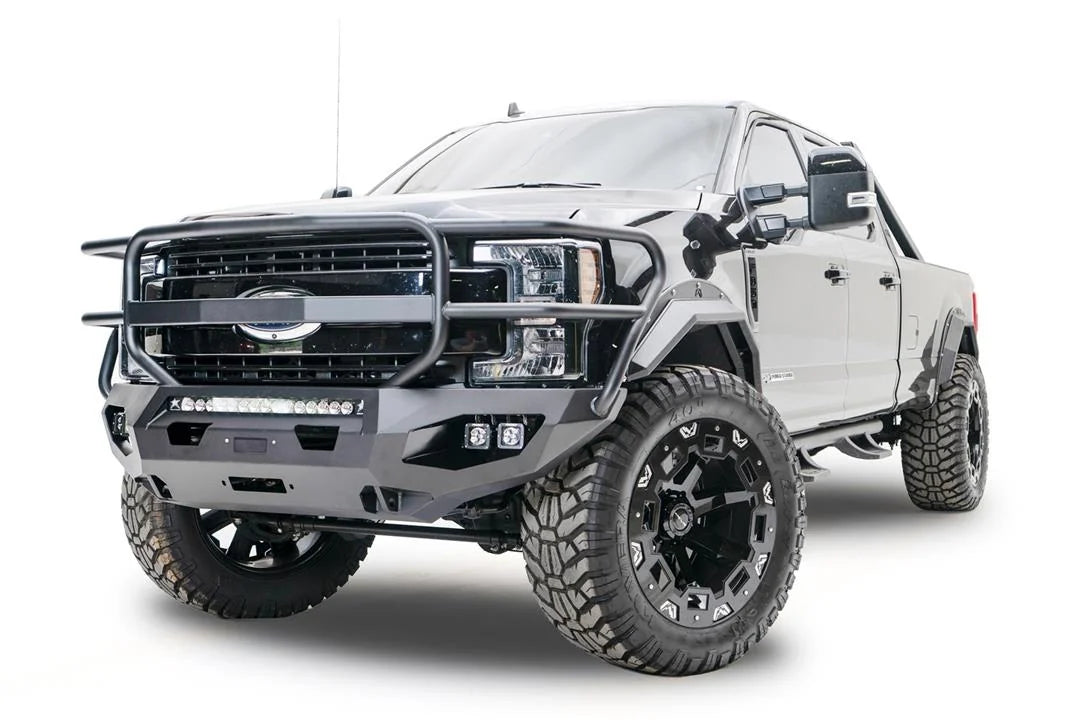 Fab Fours Matrix front bumper with full guard on a black Ford Super Duty F-250/F-350, front driver-side three-quarter view, showing full grille guard hoops, the center LED light bar, cube light pods, and the integrated winch with shackle mounts